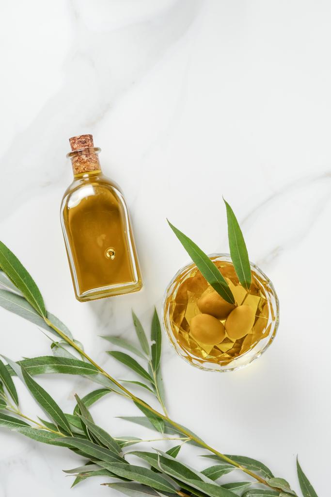 pohled z láhve a sklo s olivovým olejem na mramorový stůl - Fotografie, Obrázek