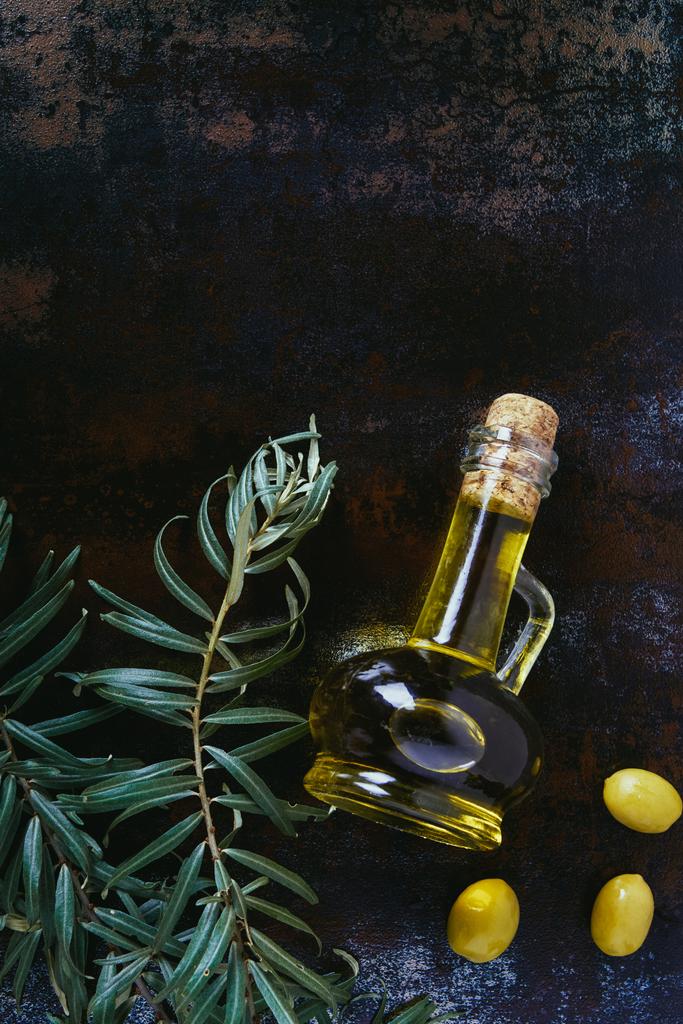 κάτοψη του μπουκάλι ελαιόλαδο, κλαδιά και νόστιμες ελιές shabby επιφάνεια - Φωτογραφία, εικόνα