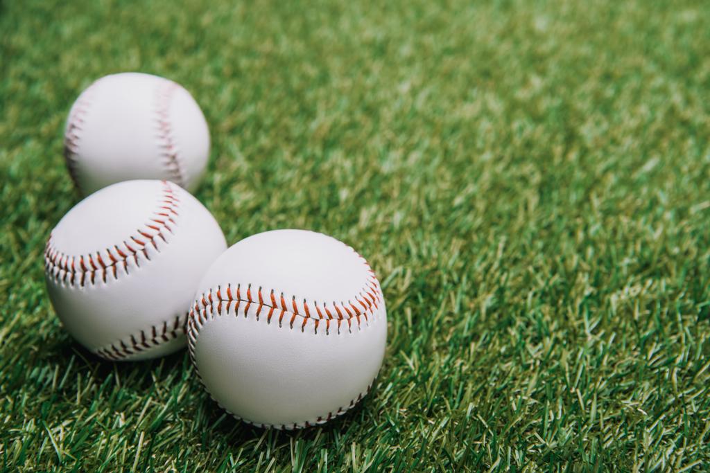 Nahaufnahme weißer Baseballbälle auf grünem Rasen - Foto, Bild