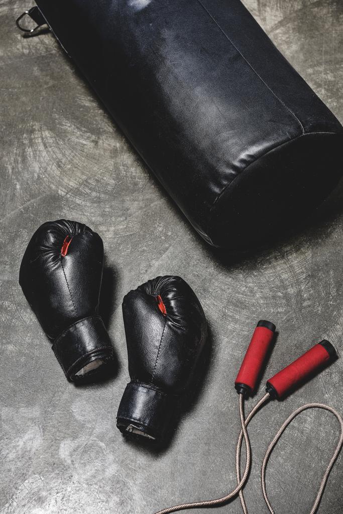 boxovací pytel s skákání lana a Boxerské rukavice na betonový podklad - Fotografie, Obrázek