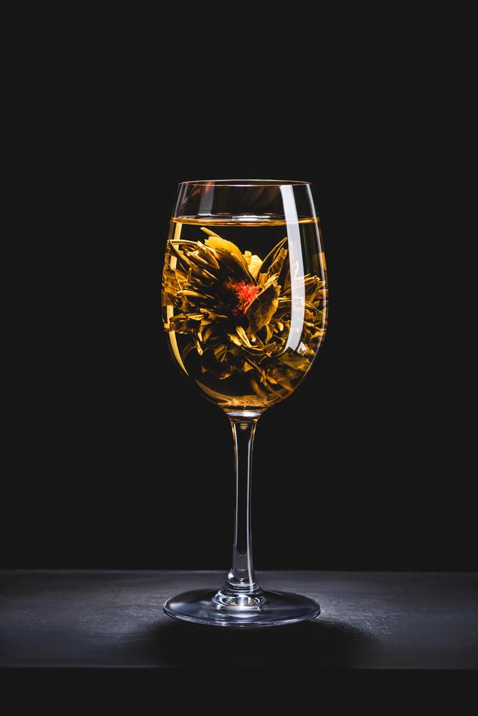 glass of chinese flowering tea on table isolated on black - Photo, Image