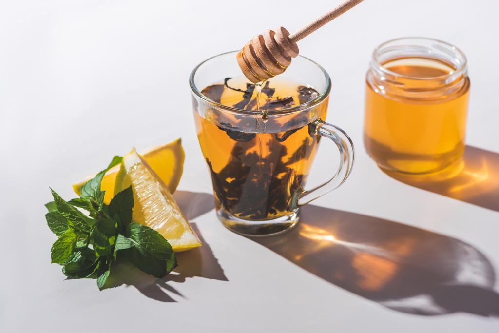 gesunder Tee mit Honig, Zitrone und Minze auf weißer Tischplatte - Foto, Bild