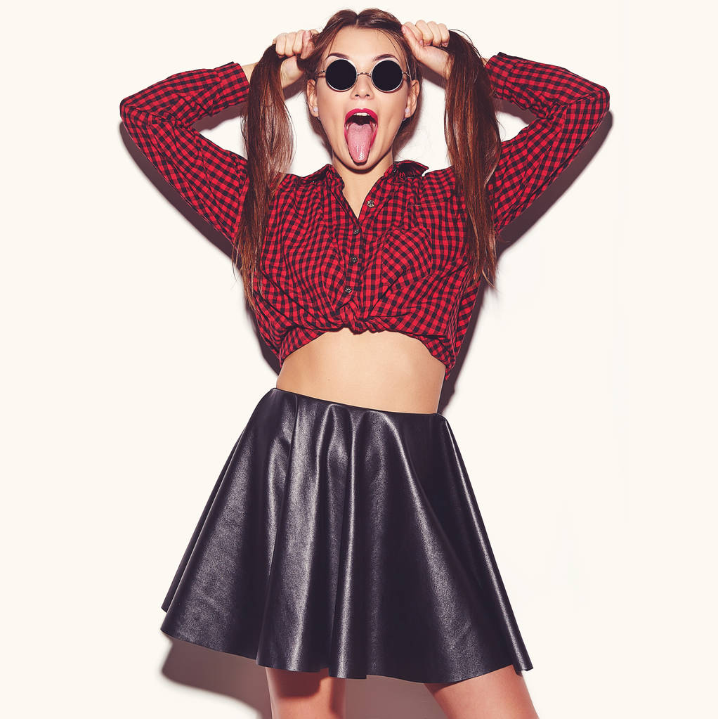 Ritratto di giovane donna felice modello con trucco luminoso e labbra colorate in estate camicia rossa a scacchi e occhiali da sole isolati su bianco. Sta impazzendo.
  - Foto, immagini