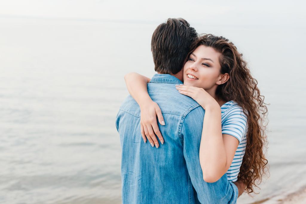 hermosa feliz pareja abrazando cerca del mar
  - Foto, Imagen