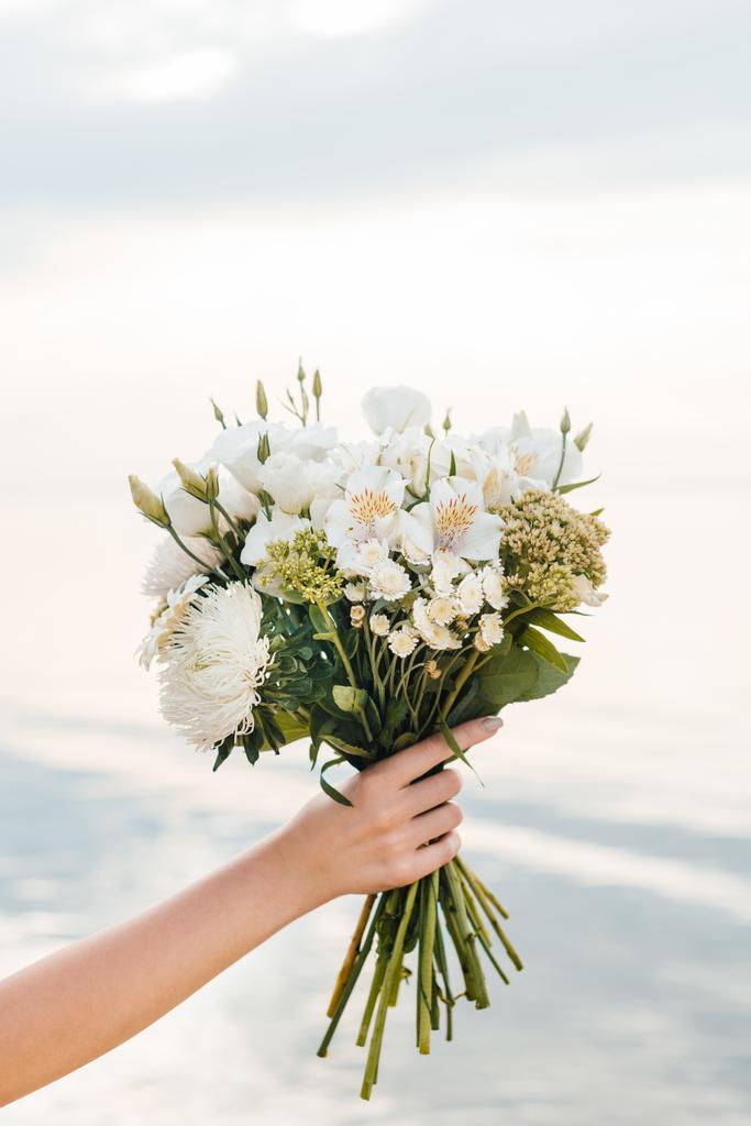 bijgesneden beeld van vrouw met prachtige boeket met witte bloemen - Foto, afbeelding