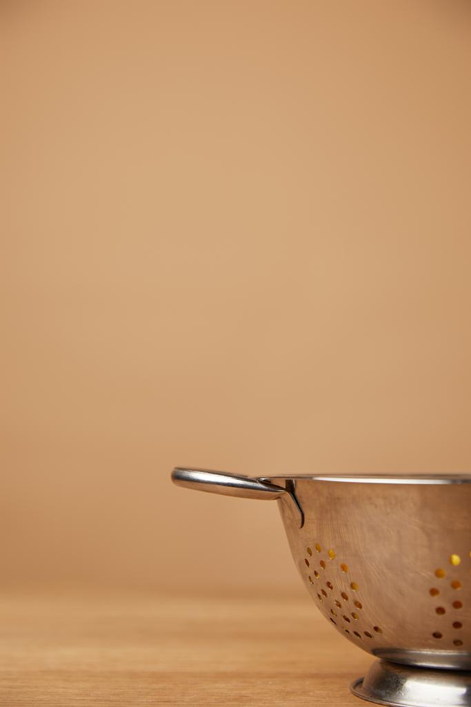 κοντινή λήψη ενός μεταλλικό σουρωτήρι με μακαρόνια στο ξύλινο τραπέζι - Φωτογραφία, εικόνα