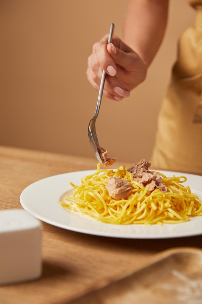 colpo ritagliato di donna che mette carne di pollo su spaghetti in piatto
 - Foto, immagini