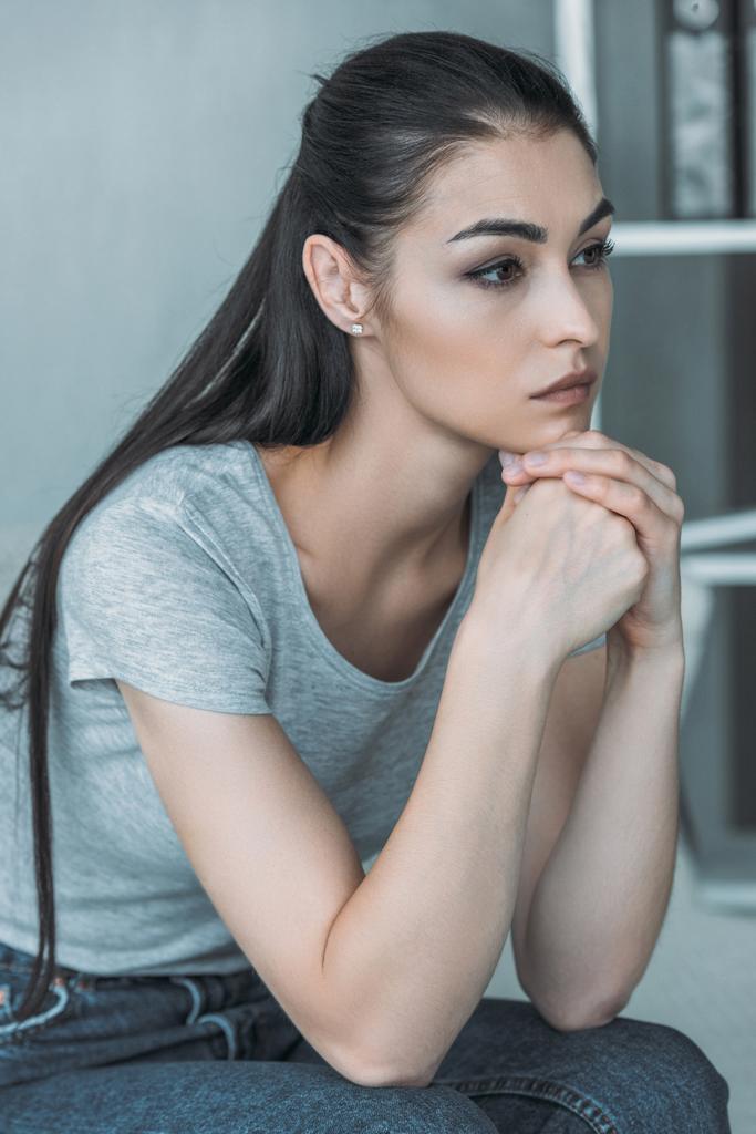 красивая грустная молодая женщина в депрессии сидя и глядя в сторону дома
  - Фото, изображение