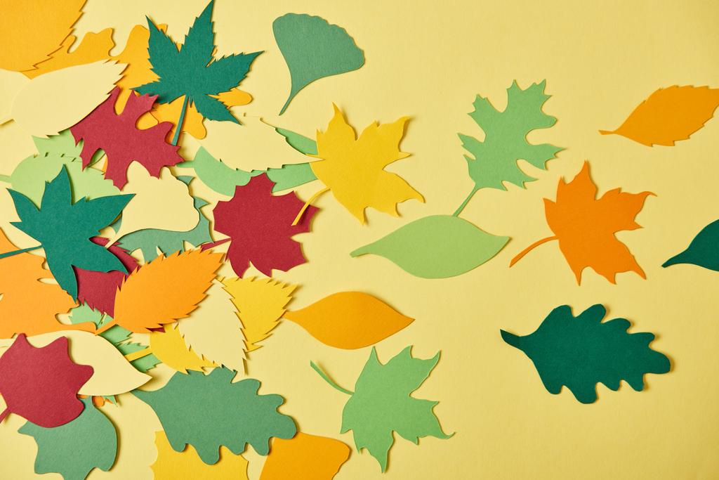 黄色の背景上に配置カラフルな papercrafted の葉を持つフラット レイアウト - 写真・画像