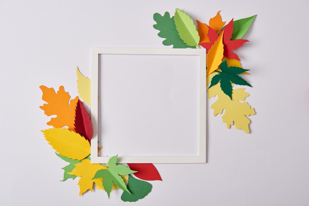 pose plate avec feuilles de papier artisanal et cadre vide sur plateau blanc
 - Photo, image