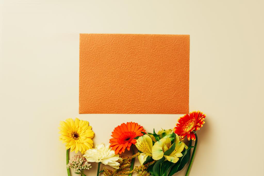 美しい花とベージュの背景の空のオレンジ カード配置とフラット レイアウト - 写真・画像