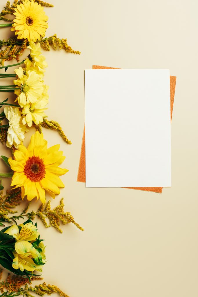 tendido plano con flores brillantes, vacías tarjetas blancas y anaranjadas sobre fondo beige
 - Foto, imagen
