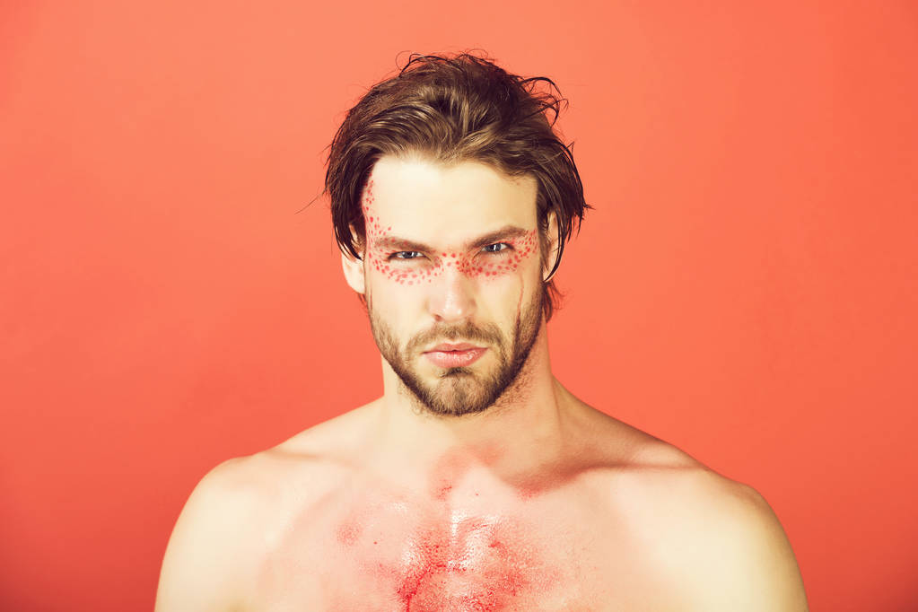 pohledný muž s kreativní módní make-up na červeném pozadí - Fotografie, Obrázek