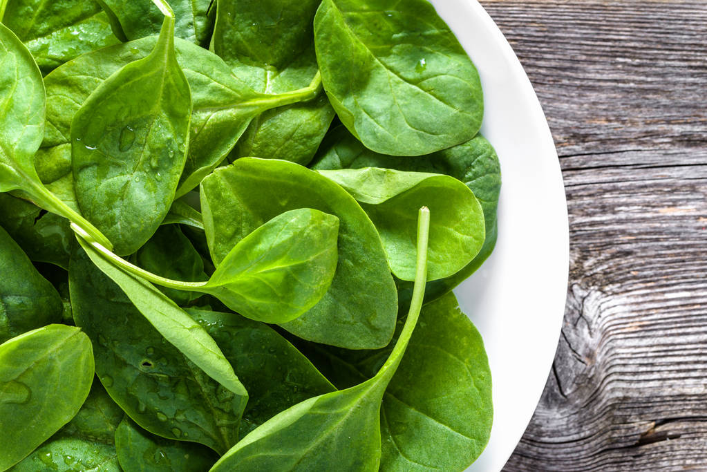 Espinafre orgânico fresco no prato, vegetais verdes folhosos, conceito de comida saudável
 - Foto, Imagem