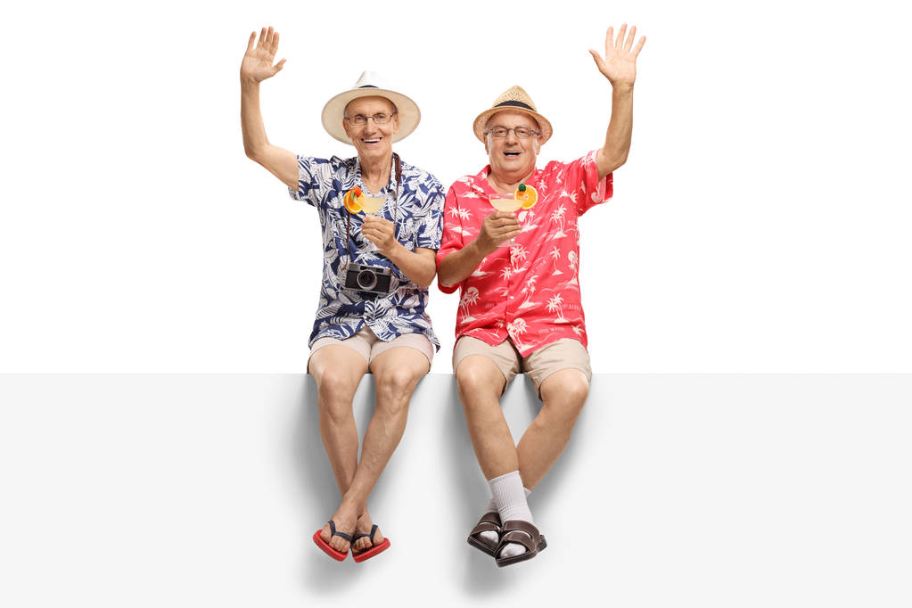 Két korrekt idősek egy nyaralás gazdaság koktélok és integetett elszigetelt fehér background - Fotó, kép