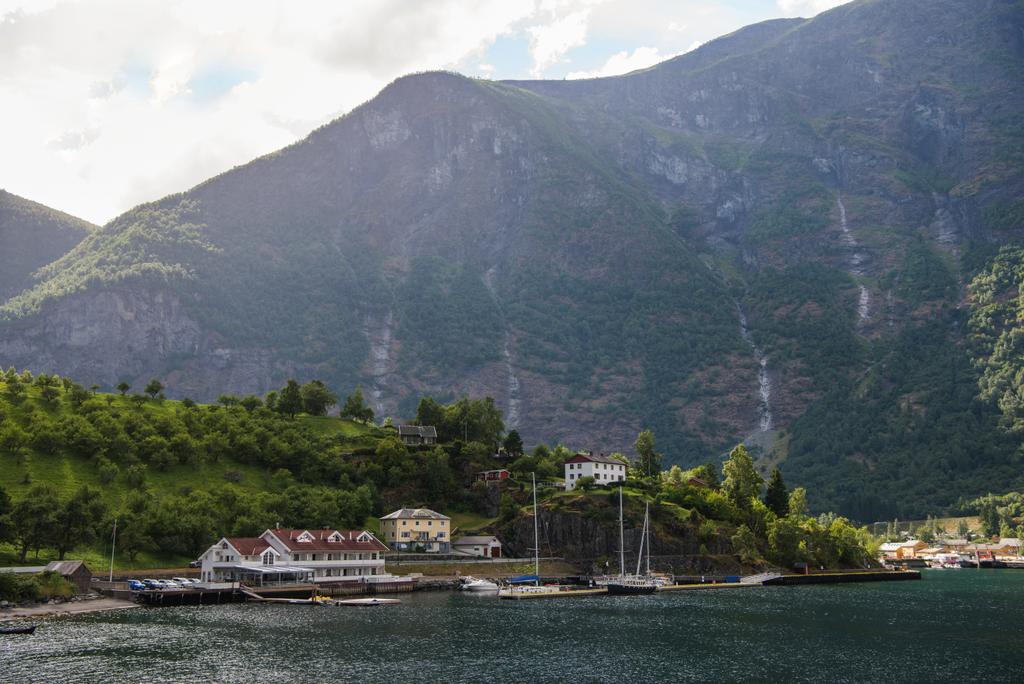 épületek és jacht Horgonyzott a nyugodt tó közelében gyönyörű hegyek Norvégiában - Fotó, kép