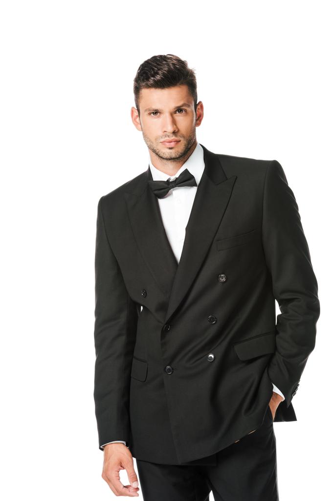 stylischer junger Mann im schwarzen Anzug blickt vereinzelt in die Kamera - Foto, Bild