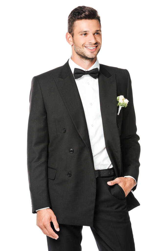 Lächelnder Bräutigam knöpft Anzug an und schaut isoliert auf weißem Grund weg - Foto, Bild