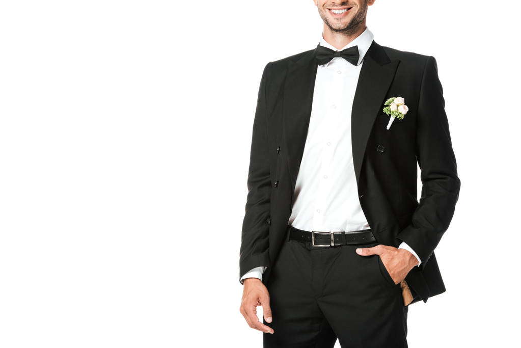 abgeschnittene Aufnahme eines lächelnden jungen Bräutigams im Anzug mit Boutonniere isoliert auf Weiß - Foto, Bild