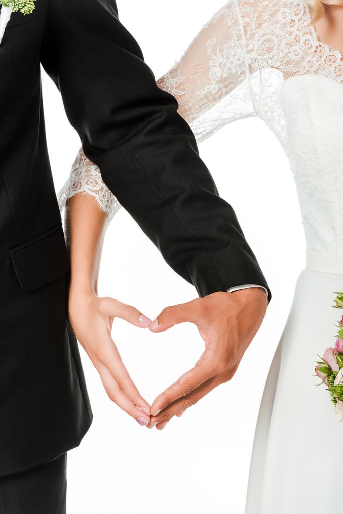 Schnappschuss von Braut und Bräutigam beim Herzenzeichen mit isolierten Händen auf Weiß - Foto, Bild