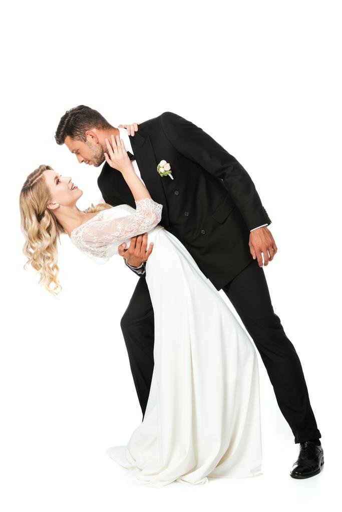 jeune marié passionné embrassant pendant la danse et se regardant isolé sur blanc
 - Photo, image