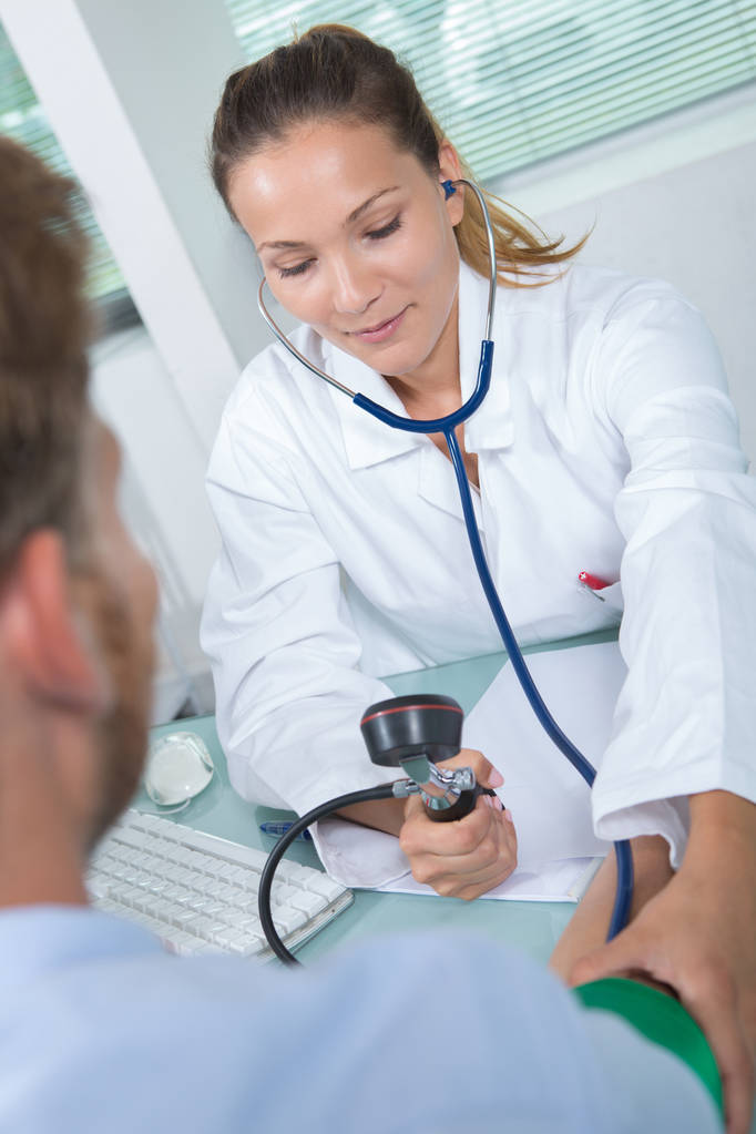 Femme médecin mesure la pression artérielle de l'homme avec tonomètre
 - Photo, image