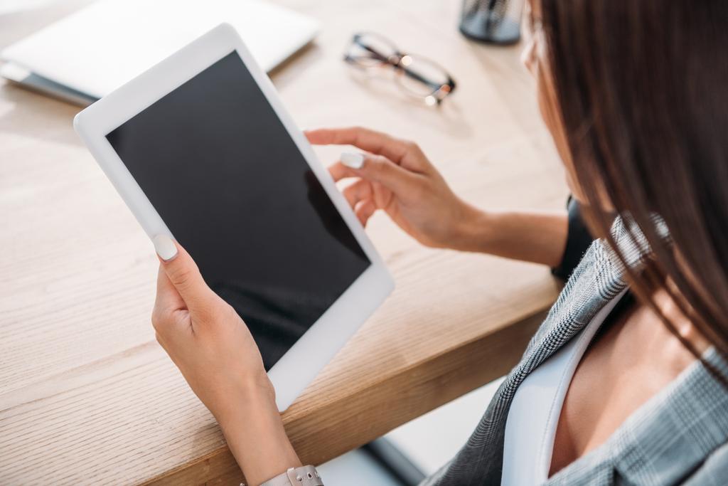 высокий угол обзора деловая женщина держит планшет с пустым экраном в офисе
 - Фото, изображение