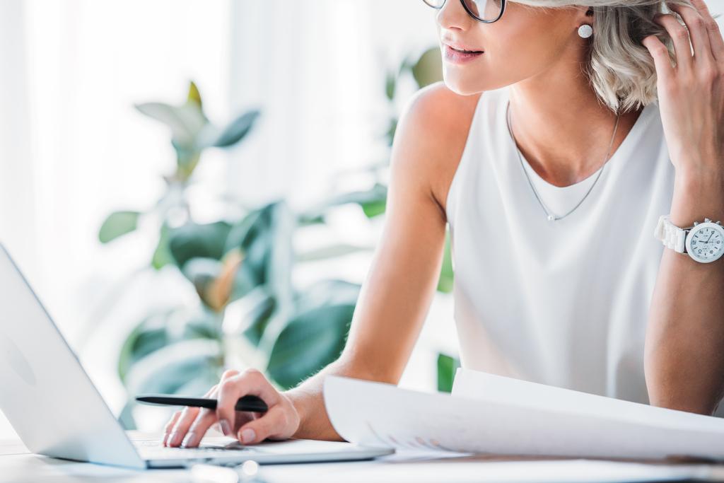 abgeschnittenes Bild einer Geschäftsfrau mit Laptop im Büro - Foto, Bild