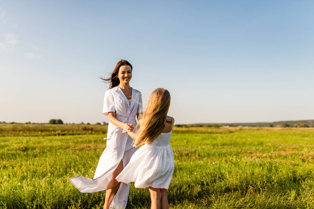 belle mère heureuse et fille jouant dans la prairie verte
 - Photo, image