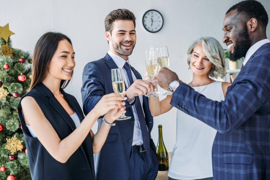 мультикультурні бізнесмени смердять келихами шампанського з ялинкою на фоні офісу
 - Фото, зображення