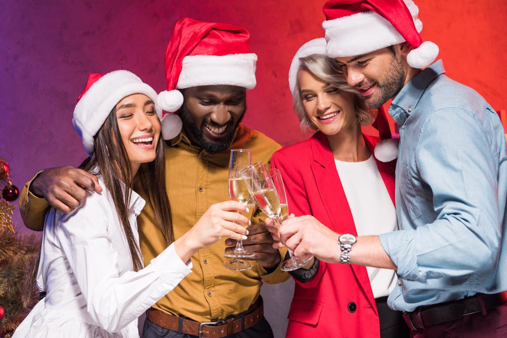 jóvenes empresarios multiculturales tintineo con copas de champán en la fiesta corporativa de año nuevo
  - Foto, imagen