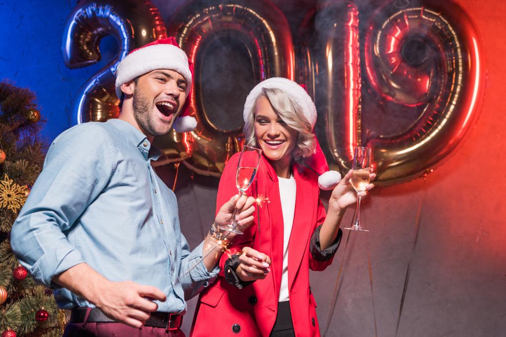 mladí podnikatelé v santa klobouky baví na novoroční firemní party - Fotografie, Obrázek