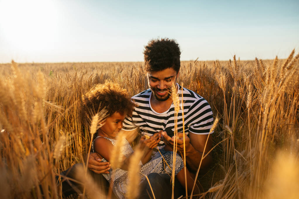 Foto de um pai e filha afro-americanos se divertindo juntos nos campos
. - Foto, Imagem