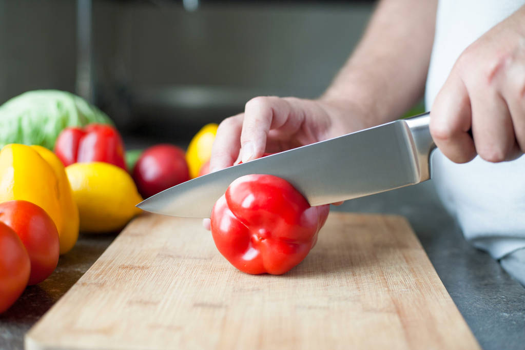 προετοιμασία σαλάτα - κοπή κόκκινη πιπεριά σε κομμάτια - Φωτογραφία, εικόνα