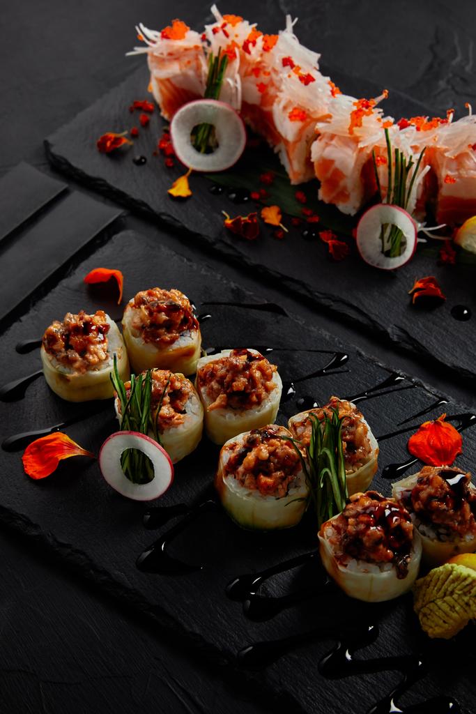 vista de cerca del rollo en mamenori con camarones, salmón y aguacate en salsa nigiri y rollo con anguila cremosa y mayonesa kimchi
  - Foto, imagen