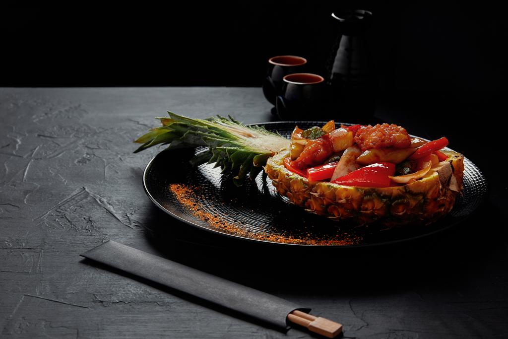 köstliches japanisches Gericht serviert in halbierter Ananas und Stäbchen - Foto, Bild
