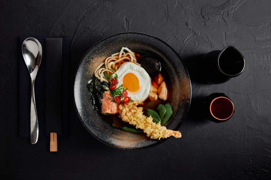 vista dall'alto di deliziosa zuppa tradizionale giapponese in ciotola con bacchette e cucchiaio
  - Foto, immagini