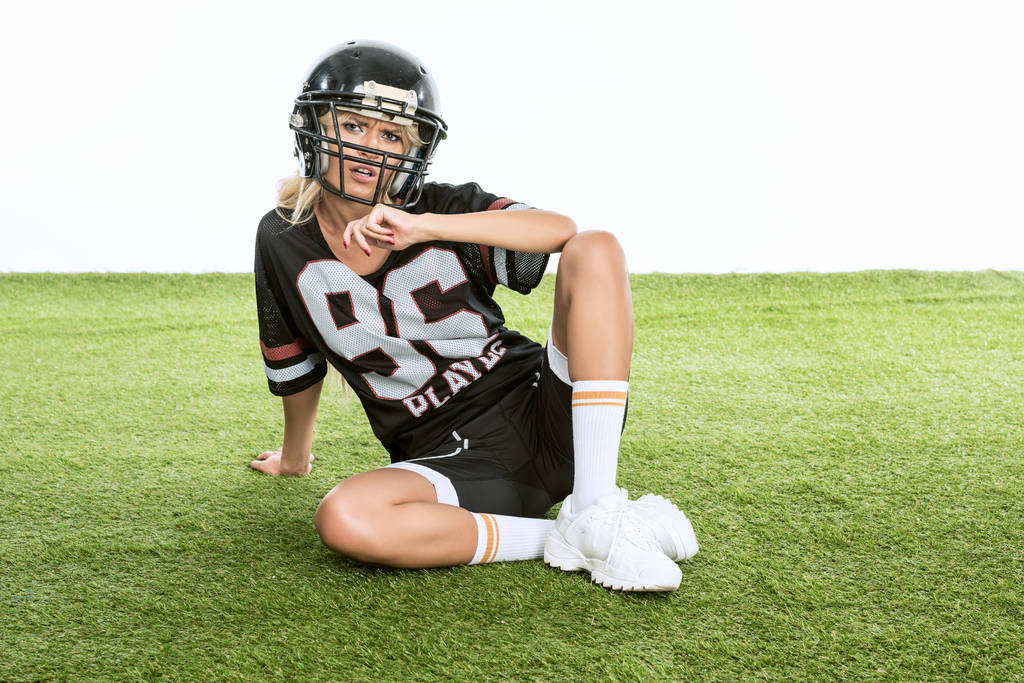 mujer joven deportiva en uniforme de fútbol americano aislado en blanco
 - Foto, Imagen