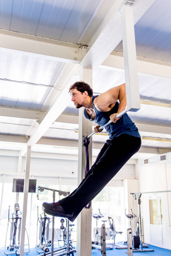 Молодой мускулистый человек делает упражнения по кроссфиту в спортзале
 - Фото, изображение