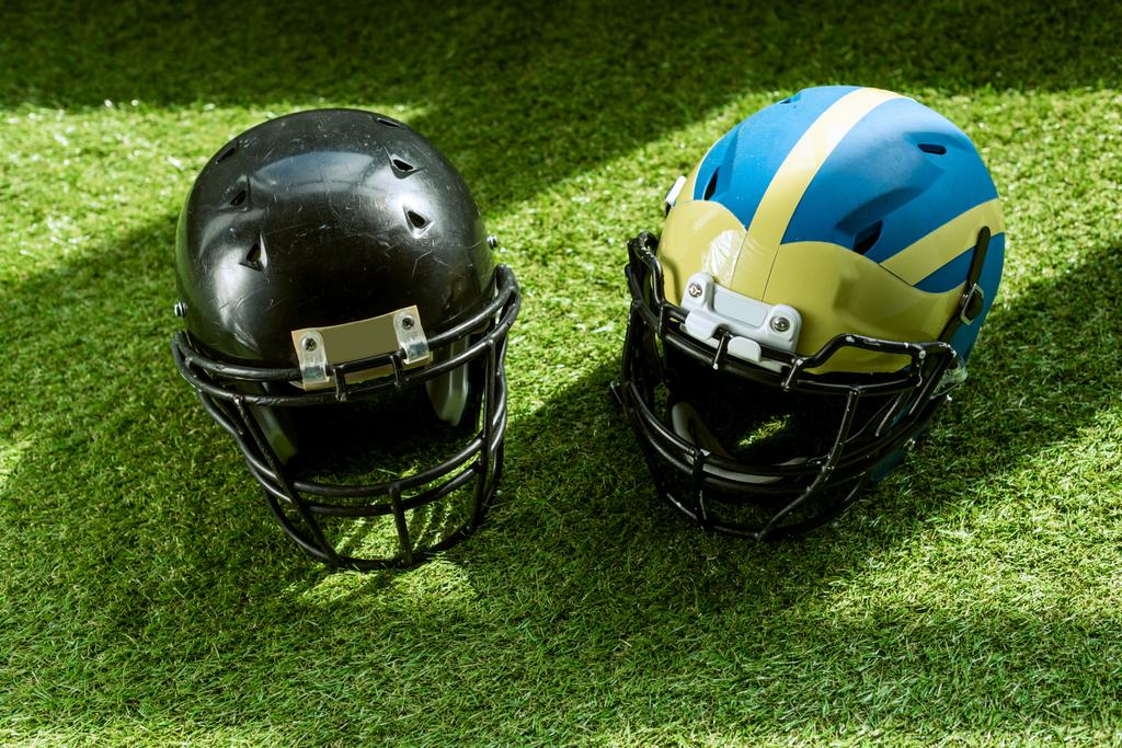 High-Winkelblick auf American Football-Schutzhelme auf grünem Gras - Foto, Bild