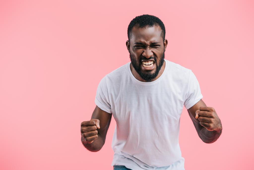 retrato de homem americano africano irritado em camisa branca isolado em rosa
  - Foto, Imagem