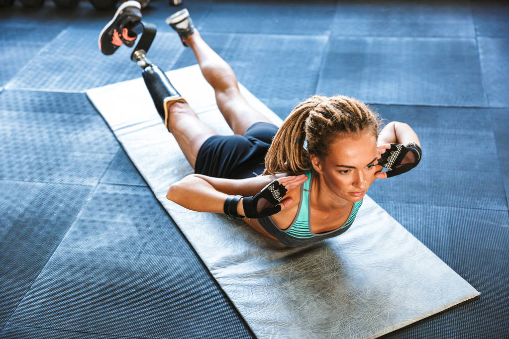 Wizerunek niesamowite silne wyłączone sportowe kobieta zrobić sport ćwiczenia w siłowni. - Zdjęcie, obraz