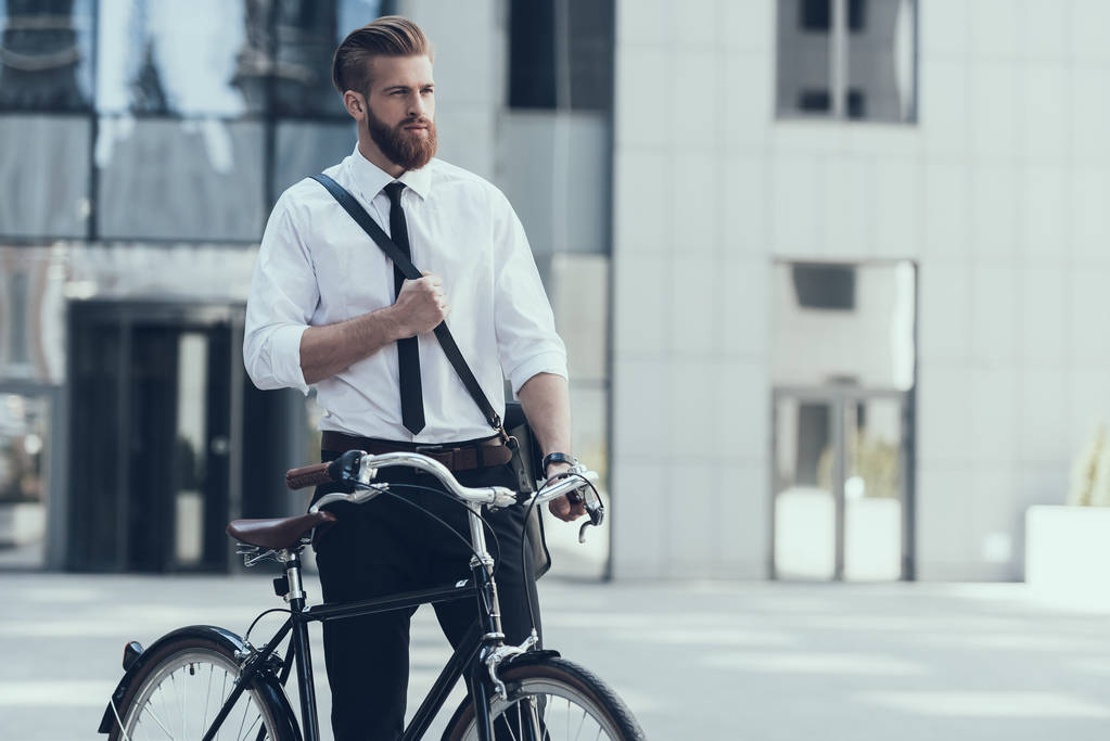 Молодий красивий бізнесмен їде на велосипеді на роботі. Екологічно чистий транспорт та здоровий активний спосіб життя. Бізнесмен їде на велосипеді, щоб працювати на Урбан-стріт. Концепція бізнесу. Концепція стилю
. - Фото, зображення