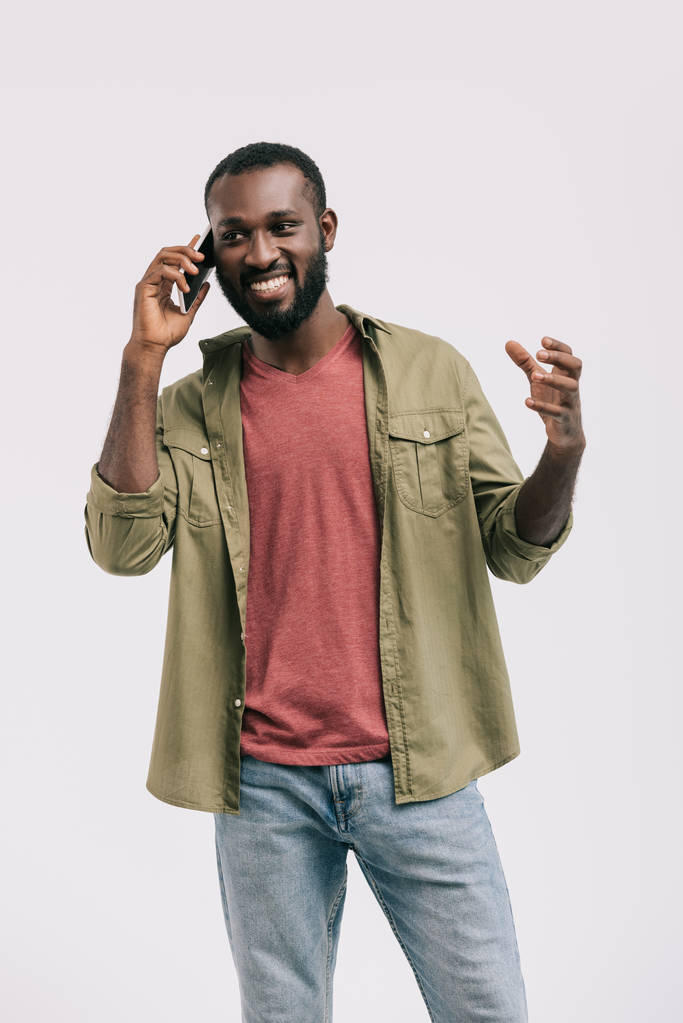 ευτυχισμένος όμορφος αφρικανική αμερικανική άνθρωπος μιλάμε από smartphone και χειρονομώ απομονωθεί σε λευκό - Φωτογραφία, εικόνα