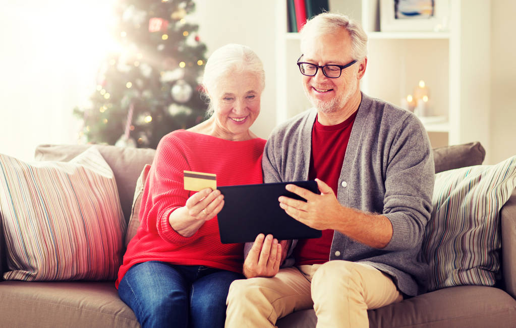 feliz pareja de ancianos con la tableta de PC en Navidad
 - Foto, imagen