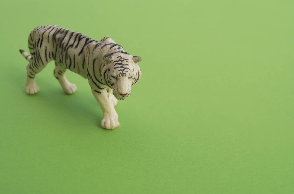 Zvířete tiger je hračkou pro děti. Plastová figurka pro hru. Zelené pozadí. Farma a zoo. - Fotografie, Obrázek