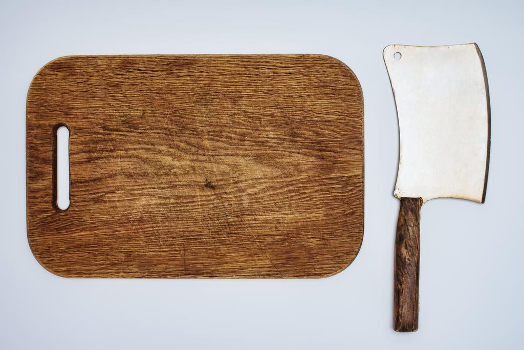 top view of wooden chopping board and meat knife isolated on grey - Photo, Image