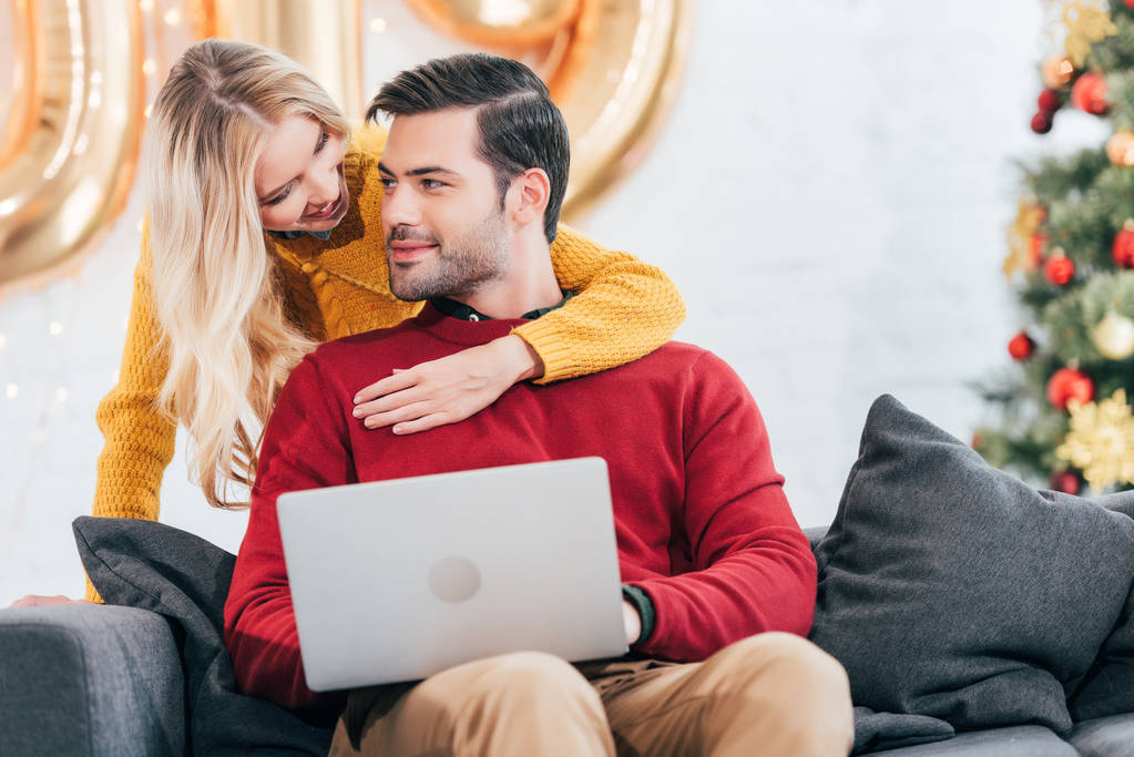 casal feliz usando laptop em casa na véspera de Natal
 - Foto, Imagem