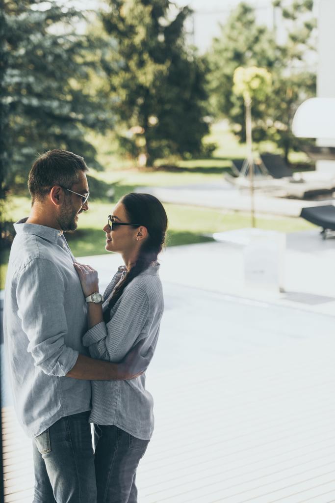a férfi napszemüveg átölelve barátnője: country house oldalnézete  - Fotó, kép
