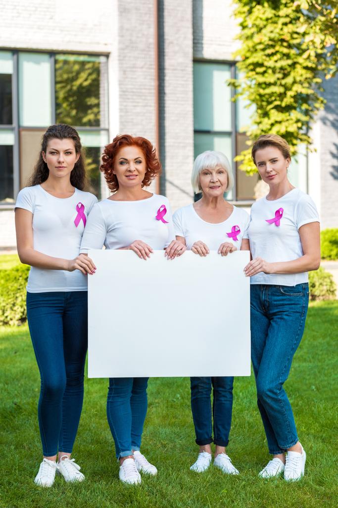 naiset, joilla on rintasyöpä tietoisuutta nauhat tilalla tyhjä banneri ja katsot kameraa
  - Valokuva, kuva